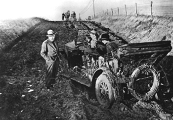 "Prior to paved roads, pleasure excursions in the family car could end in disaster in North Carolina. Luckily for this mud-bound convertible and family, the approaching team of horses would pull them free from their prison." Image from the State Archives of North Carolina, N62.8.42.