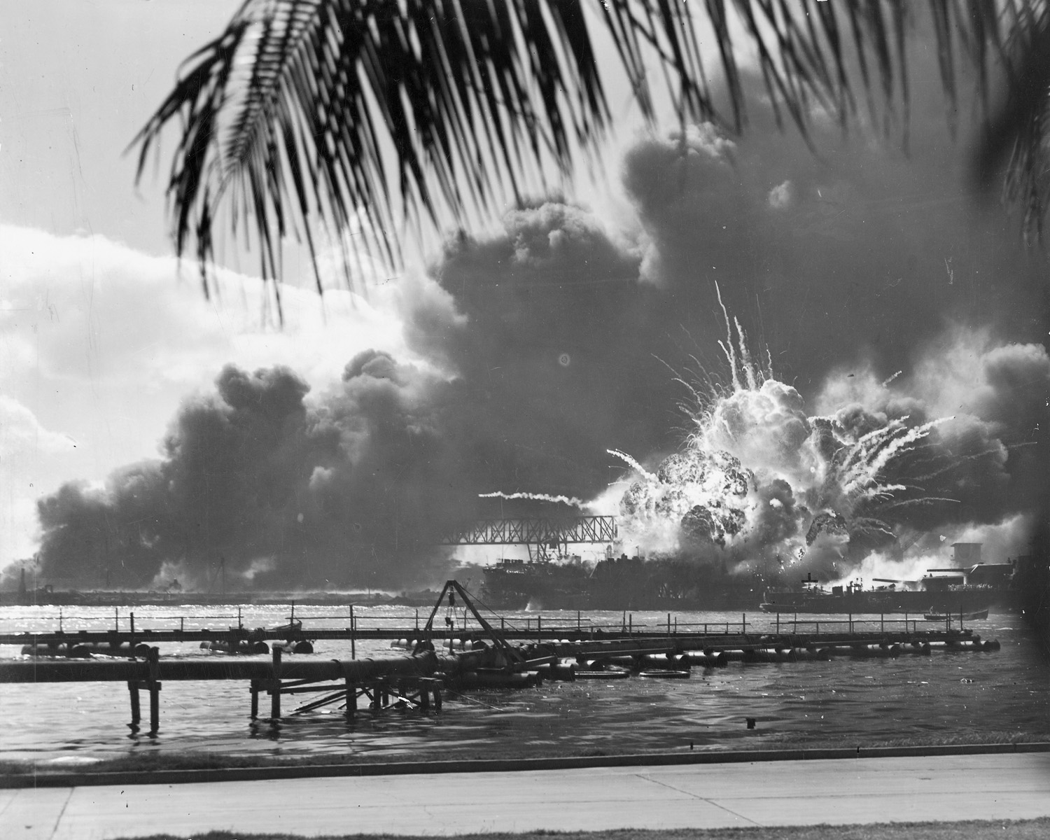 The explosion of the U.S.S. Shaw in the harbor. Cinders and shrapnel fly from the boat.